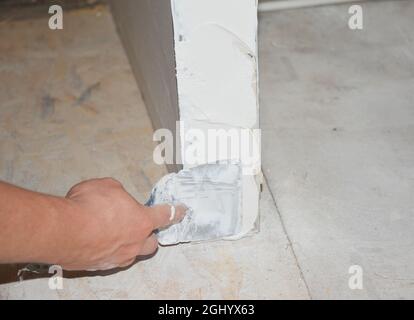 Skim coating the outside corner covering the angle bead with a compound using taping knife. Stock Photo