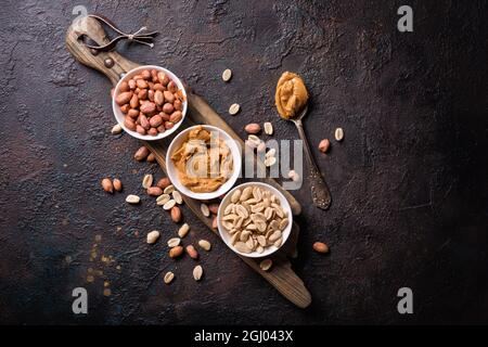 Sweet peanut paste or butter in bowl on wooben board and dark concrete background Stock Photo