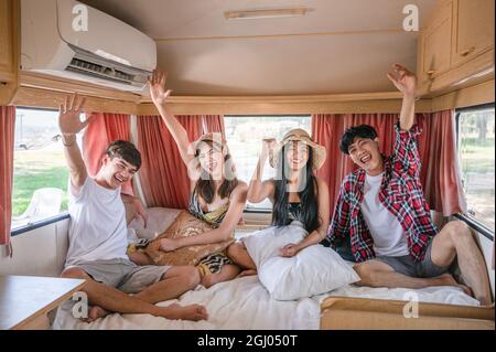 Group of young asian friends having fun inside camper van on weekend Stock Photo