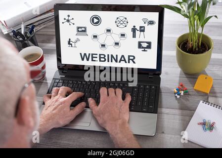Webinar concept shown on a laptop used by a man Stock Photo