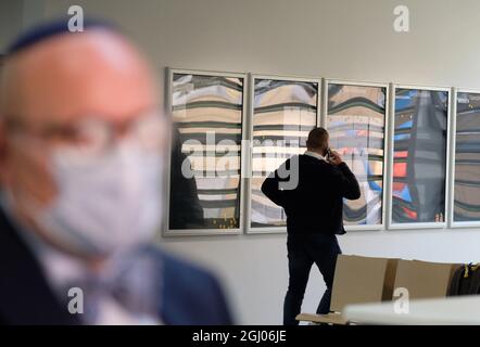 Chemnitz, Germany. 08th Sep, 2021. Kevin A. (r), defendant in a trial for aggravated assault and other offences, walks along the foyer of the district court while Uwe Dziuballa, boss of the Jewish restaurant 'Schalom', talks to media representatives. The defendant from Lower Saxony allegedly threw paving stones at the inn on August 27, 2018, injuring the landlord. Credit: Sebastian Willnow/dpa-Zentralbild/dpa/Alamy Live News Stock Photo