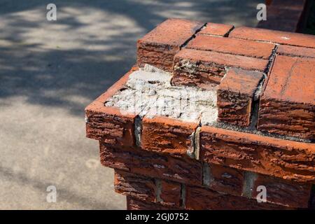A corner column of a brick wall surrounding a house, missing a few bricks and needing repair. In Arlington, Virginia. Stock Photo