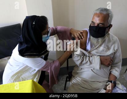 Non Exclusive: CHANDPUR, BANGLADESH- SEPTEMBER 7:  A person receives the second dose during a mass vaccination campaign against Covid-19 disease. The Stock Photo