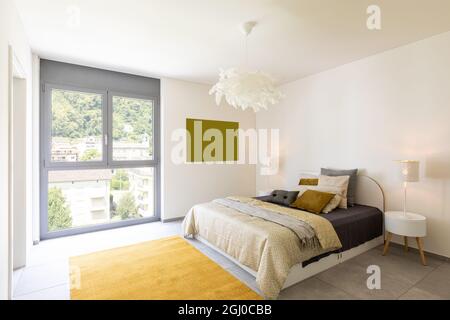 Interior of elegant double bedroom. Colorful blankets and pillows. Stock Photo