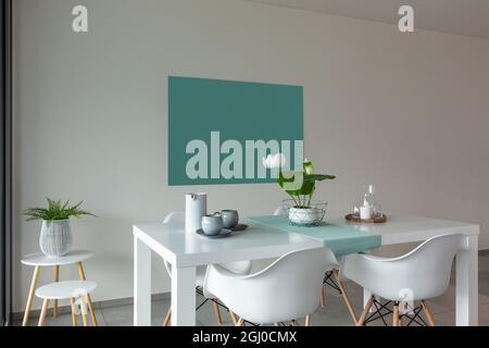 Dining room with white table and white chairs. Modern and linear furniture. Stock Photo