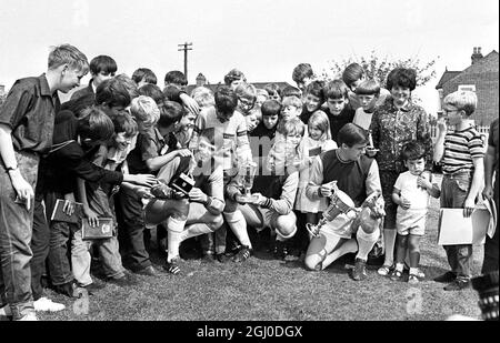 Showing hard won trophies to eager young fans during West Ham's press day at Chadwell Heath are West Ham players and members of England's World Cup winning team . Left to right: Geoff Hurst, Bobby Moore and Martin Peters London. 16th August 1966. Stock Photo