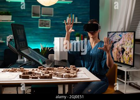 Modern business woman with vr glasses for innovation development vision using interactive software. Virtual designer working on holographic simulation experience for building model Stock Photo
