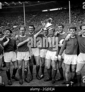 1963 FA Cup Final Manchester United V Leicester City After the presentation of the trophy and medals by H.M The Queen, Manchester United captain and members of the team proudly show the cup to the crowd. Left to right are: Outside left Bobby Charlton, left back and captain Noel Cantwell, right half Pat Crerand, inside right Albert Quixall with the cup balanced on his head and centre forward David Herd. 25th May 1963. Stock Photo