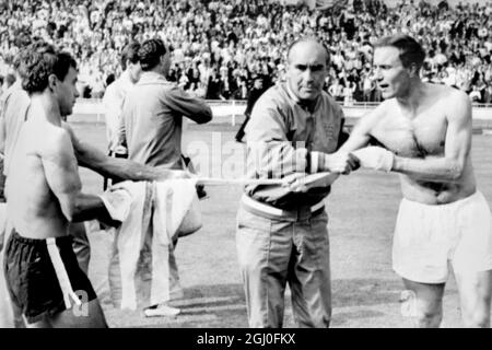 1966 World Cup England v Argentina England team manager Alf Ramsay appears to be acting as referee as England's George Cohen (right) and Argentine's Alberto Gonzales exchange shirts at the end of the World Cup quarter final match which England won 1-0. 23rd July 1966 Stock Photo