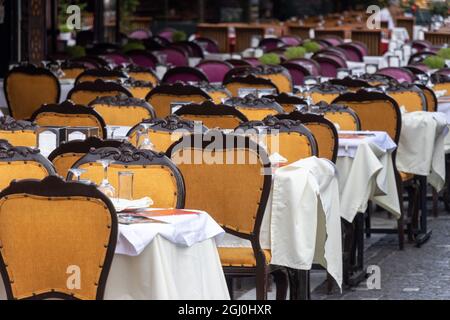 Row of empty chairs and tables in outdoor restaurant. No people Stock Photo