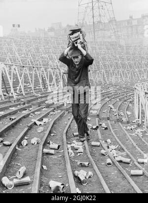 Glasgow, Scotland: A little litter goes a long way, and groundsman Bert Currie carries a sack of beer cans when clearing-up started at Hampden Park on October 25th after October 23rd (Saturday)'s Rangers versus Celtic Scottish League Cup Final It was estimated that more than 50,000 cans - bottles were not in the count - were left lying on the terracing by fans. 26th October 1965 Stock Photo