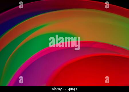 Folded paper lit with colors to create an abstract colorful image. Stock Photo