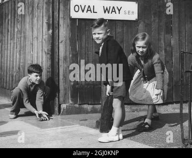 Children playing a game of cricket in the street - Oval Way is the road sign behind them - August 1957 ©TopFoto Stock Photo