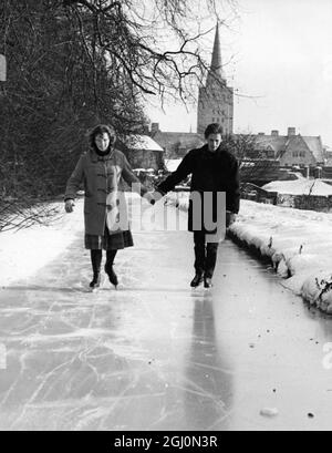Students at Oxford are takinga advantage of the frozen river and canal to enjoy the natural skating facilities offered. Studets are sending home for their skates and the local sports shops and second hand stors are doing a brisk trade in winter sports equipment. Photo shows: L-R Anna Evans , aged 20 and Peter Haxroth , aged 21 , two of the Oxford students skating on the canal 18th January 1963 Stock Photo