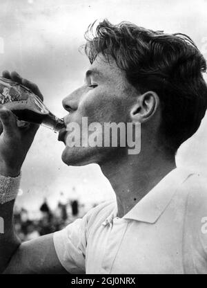 Jacques Brichant from Belgium gulps down a soft drink after winning his match against American Victor Seixas during the first day's play in the Davis Cup Challenge Round match which the Belgian won , Brisbane , Queensland , Australia 22 December 1953 Stock Photo