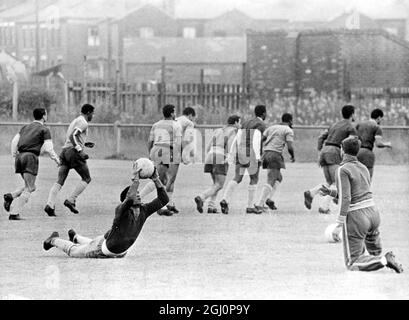 Brazilians training at Bolton . Bolton , Lancs , England : Paulo Amaral , trainer of the Brazilian footballers , seen throwing the ball to Manga , one of the two goal - keepers , as other players train in the background . Brazil meet Hungary at Goodison Park , Liverpool tonight . 15 July 1966 Stock Photo