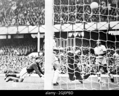 Simoes (left) of Portugal is pictured scoring Portugal 's first goal in the 15th minute of the World Cup Match against Brazil in Liverpool . Brazilian goalkeeper Manga is seen well-beaten . Portugal led 2 - 0 at half time . 19 July 1966 Stock Photo