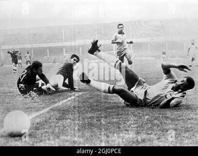 Hungarian Goalie in action . Liverpool , England : Hungarian goalkeeper , Josef Gelei , is pictured with Kalman Miszoly , as the ball goes over the line during their World Cup match , with Brazil ' s Jair ( right ) looking on . Hungary beat Brazil 3 - 1 . 15 July 1966 Stock Photo