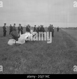 ST JOHNS AMBULANCE MEN STAND OVER MINI COOPER AT SILVERSTONE RACING 8 JULY 1961 Stock Photo