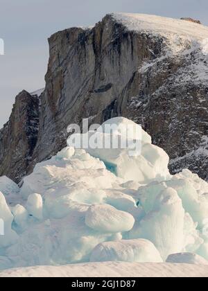 Icebergs in front of Storen Island, frozen into the sea ice of the Uummannaq fjord system during winter. Greenland, Danish Territory Stock Photo