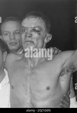 With a swollen eye and bettered face Henry Cooper cannot yet manage a smile as he hears he has become the new British and Empire heavyweight champion by cutpointing Brian London at Earls Court , London . 12 January 1959 Stock Photo