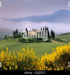 Tuscan farmhouse with cypress trees in misty landscape at sunrise, San Quirico d'Orcia, Siena Province, Tuscany, Italy, Europe Stock Photo