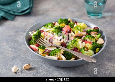 healthy broccoli salad with apple onion dried cranberries pistachio. vegan low carb diet Stock Photo