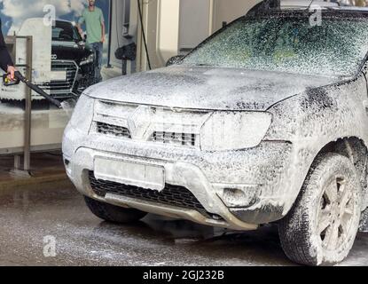 Kaliningrad, Russia, March 1, 2020. A man washes his car at a touchless car wash. Washing his brown Renault car. The SUV at the car wash. Stock Photo