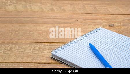 A blank sheet of paper and a ballpoint pen. Notebook and pen on the table. Stock Photo