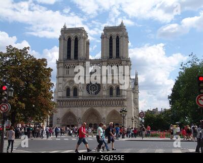 PARIS, FRANCE - Aug 28, 2010: A sunny day in Paris and tourists walking in front of the church of Notre Dame Stock Photo