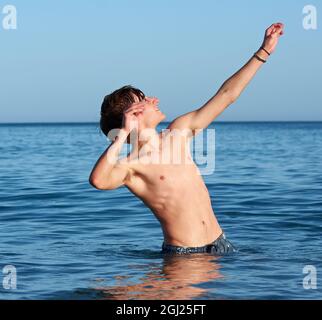 Young fit caucasian male posing and having fun in the sea Stock Photo