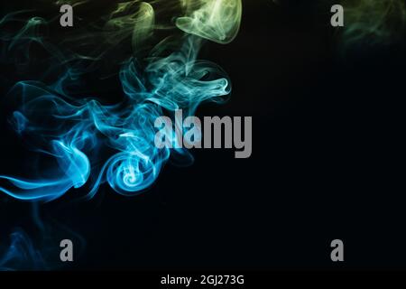 Abstract colored smoke moves on dark background. Wallpaper