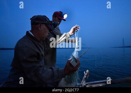 (210908) -- TIANJIN, Sept. 8, 2021 (Xinhua) -- Villagers prepare fishing net in Xiaoxinmatou Village of Baodi District in Tianjin, north China, Sept. 3, 2021. Li Chao is a post-90s born in Xiaoxinmatou Village in Baodi District. Located by the Chaobai River, the village used to witness an outflow of young people, as villagers made a living by traditional fishing and farming with low income. Like his young fellows, Li chose to be a migrant worker in the city for higher income. Waiter, chef, assembly line worker, security guard and salesman.the diligent man tried his hand at a variety of Stock Photo