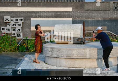 (210908) -- TIANJIN, Sept. 8, 2021 (Xinhua) -- Tourists take photos at the local cultural park in Xiaoxinmatou Village of Baodi District in Tianjin, north China, Sept. 3, 2021. Li Chao is a post-90s born in Xiaoxinmatou Village in Baodi District. Located by the Chaobai River, the village used to witness an outflow of young people, as villagers made a living by traditional fishing and farming with low income. Like his young fellows, Li chose to be a migrant worker in the city for higher income. Waiter, chef, assembly line worker, security guard and salesman.the diligent man tried his han Stock Photo