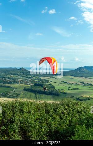 Csobanc, Hungary - August 20, 2021: Paraglider over the mountains of lake Balaton in Hungary on a summer day. Stock Photo