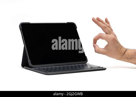 A tablet with keyboard device on a white background with hand approval Stock Photo