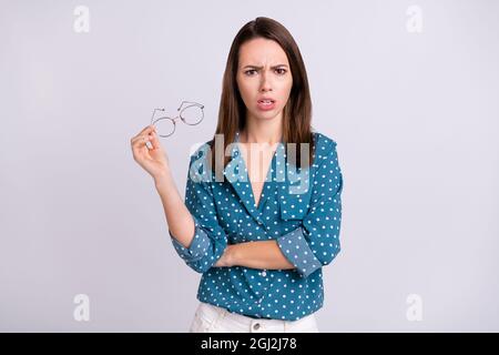 Photo of mad brunette hair millennial lady talk hold spectacles wear blue shirt isolated on grey color background Stock Photo