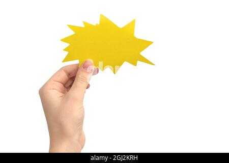 Hand with blank speech bubble in shape of boom or lightning, yellow color, isolated on a white background. Concept of giving feedback, communication a Stock Photo