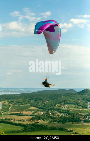 Csobanc, Hungary - August 20, 2021: Paraglider over the mountains of lake Balaton in Hungary on a summer day. Stock Photo