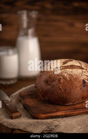 Freshly baked rye bread on a wooden cutting board. Selective focus. Stock Photo