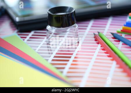 Magnifier pencils and color palette swatches on table Stock Photo
