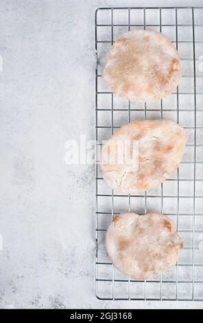 Fresh baked pita bread on a colling grid, empty copy space for text Stock Photo