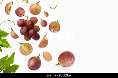 Falling red grape with leaves, isolated on white background, selective focus Stock Photo