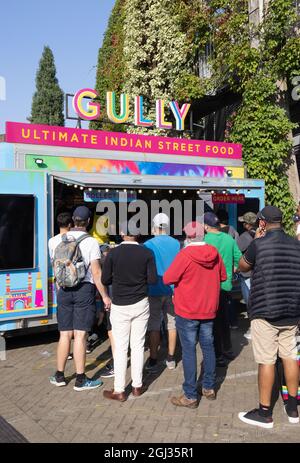 Multicultural UK; People buying street food from a Gully Indian Street Food stall, the Oval, Kennington London UK, example of multicultural London Stock Photo