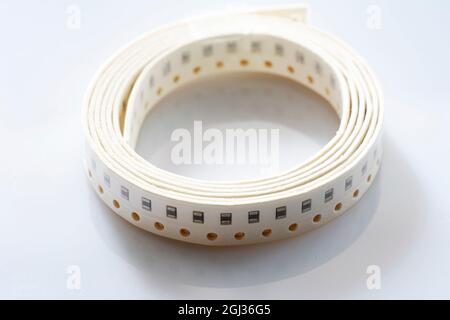 Electronic component on white background. SMD components in black plastic carrier tape with copyspace Stock Photo