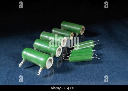 The green resistors are lying on the table with a reflection. Radio components on a black background Stock Photo