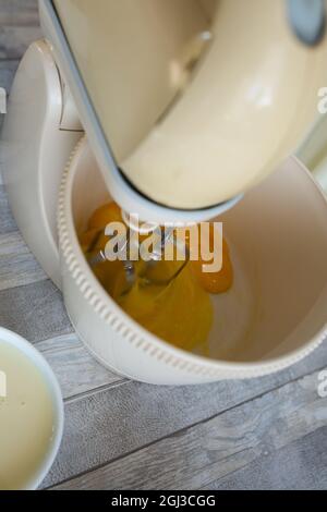 Cake making process. The mixer beats the eggs in the dough bowl. Step by step recipe for chocolate cake. Series. Baking concept. Stock Photo