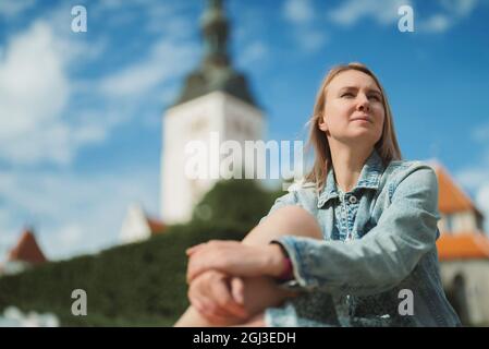 Woman resting against church in old Tallinn. Stock Photo