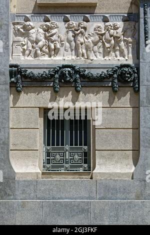 Window with a figured lattice and a bas-relief on top of the facade of the building. From the Windows of the World series. Stock Photo
