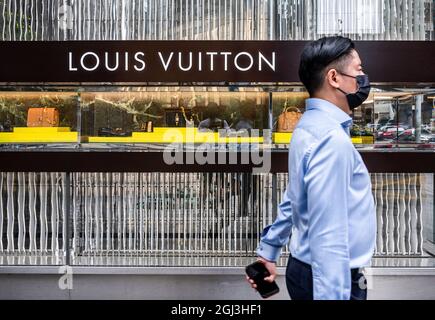 A man walks in front of the Louis Vuitton store in the Zorlu